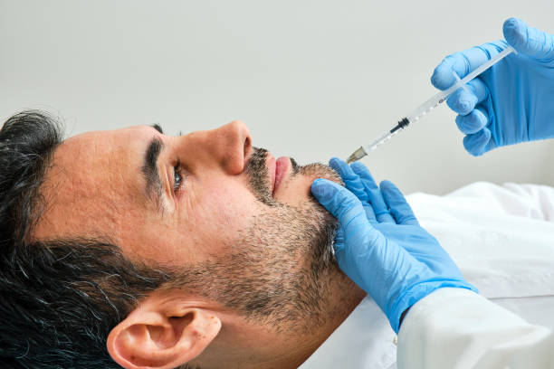 dark-haired man undergoing aesthetic treatment in the chin area with botulinum toxin